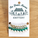 translucent teal glass bead ring-style stitch markers in the yukon river colour with gold wire