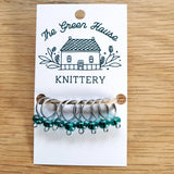 translucent teal glass bead ring-style stitch markers in the yukon river colour with silver wire