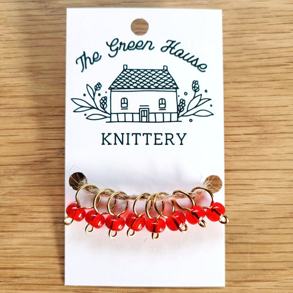 bright red glass bead ring-style stitch markers in the berries colour with gold wire
