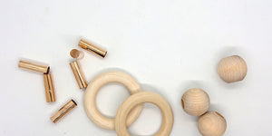 Macramé notions, including brass tubes, wood rings, and round wood beads.